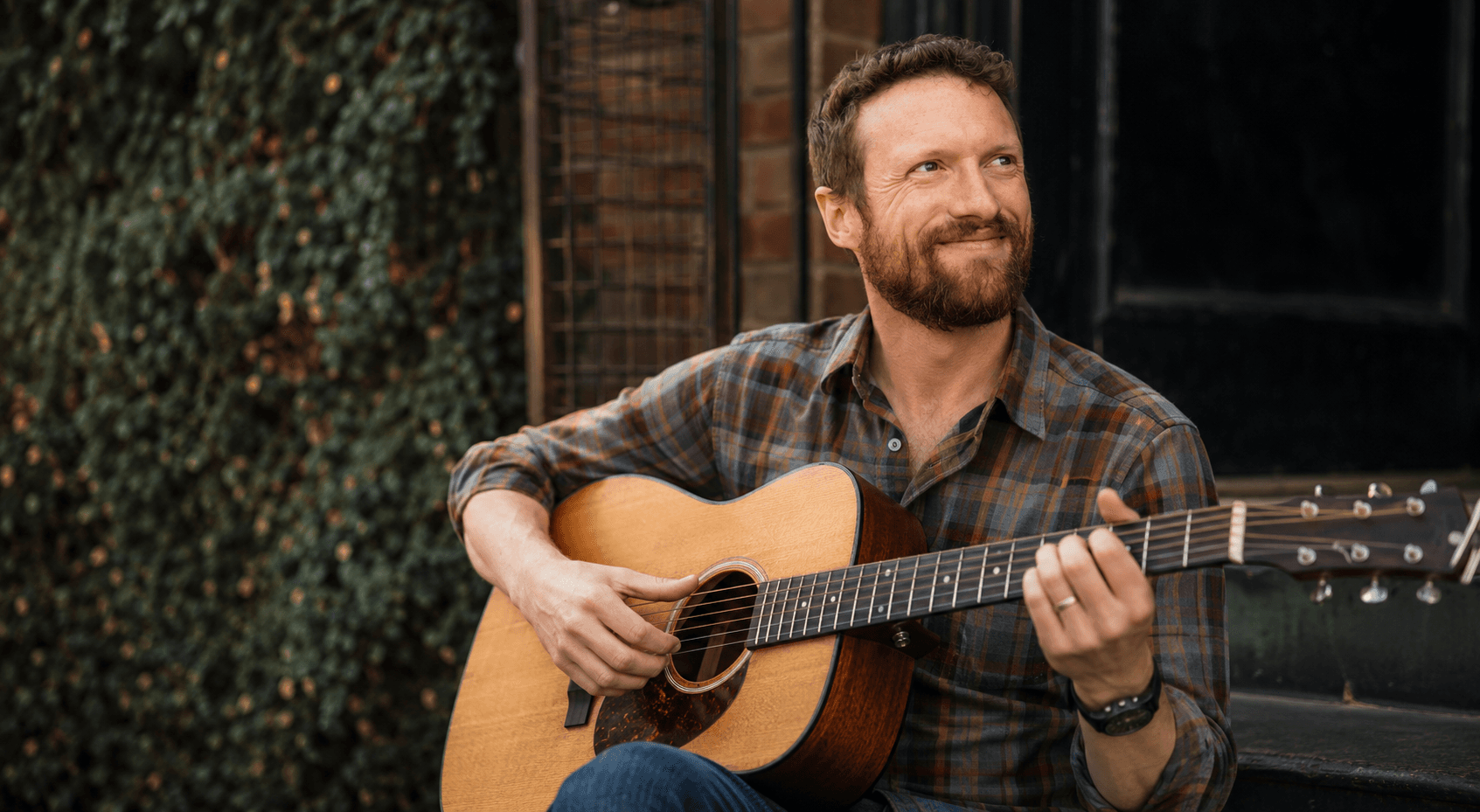 John Will playing an acoustic guitar
